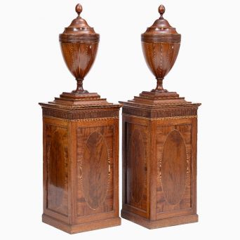 A pair of George III mahogany cutlery urns on pedestal cabinets in the Sheraton style